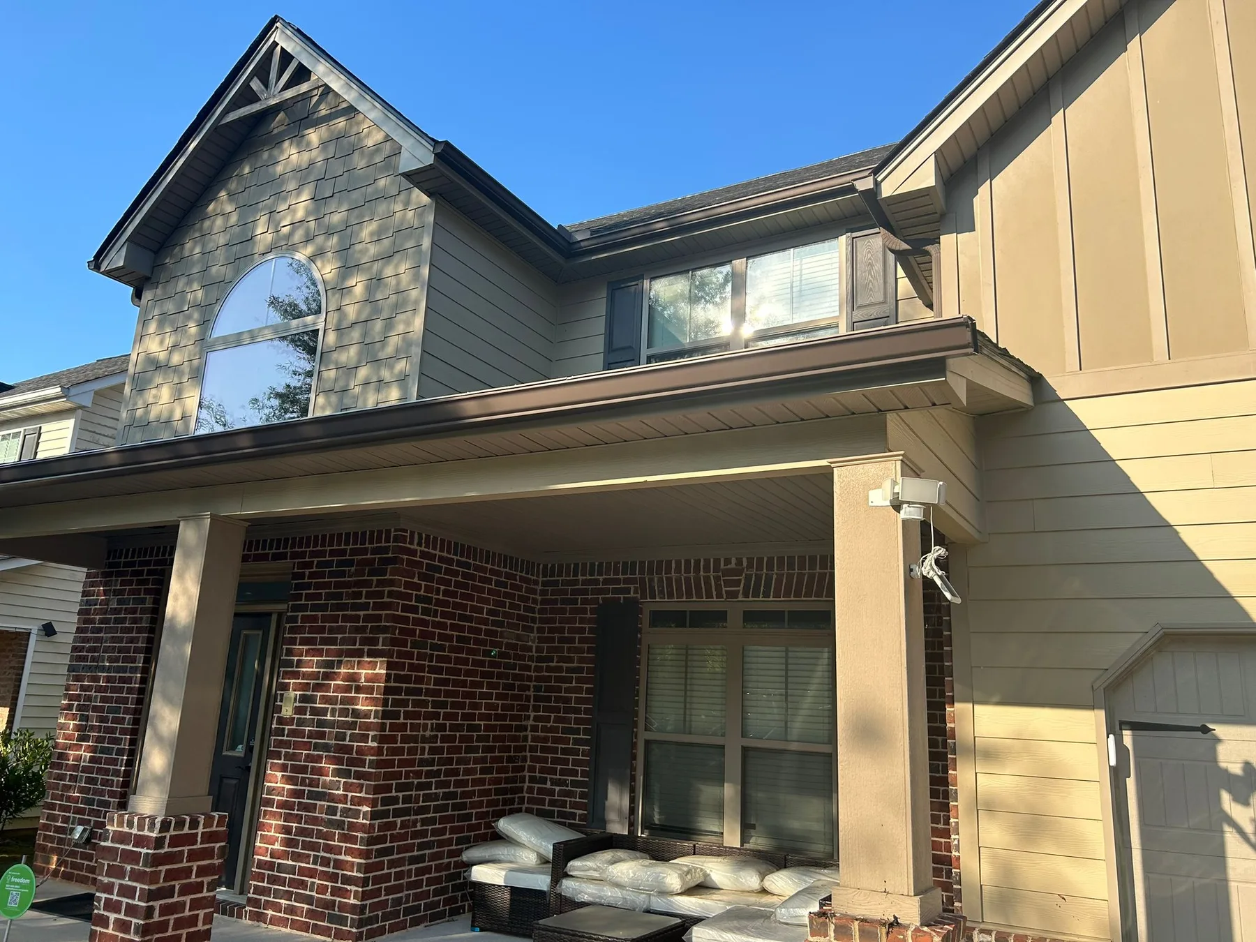 Completed seamless gutter installation on a home with a gray shake gable