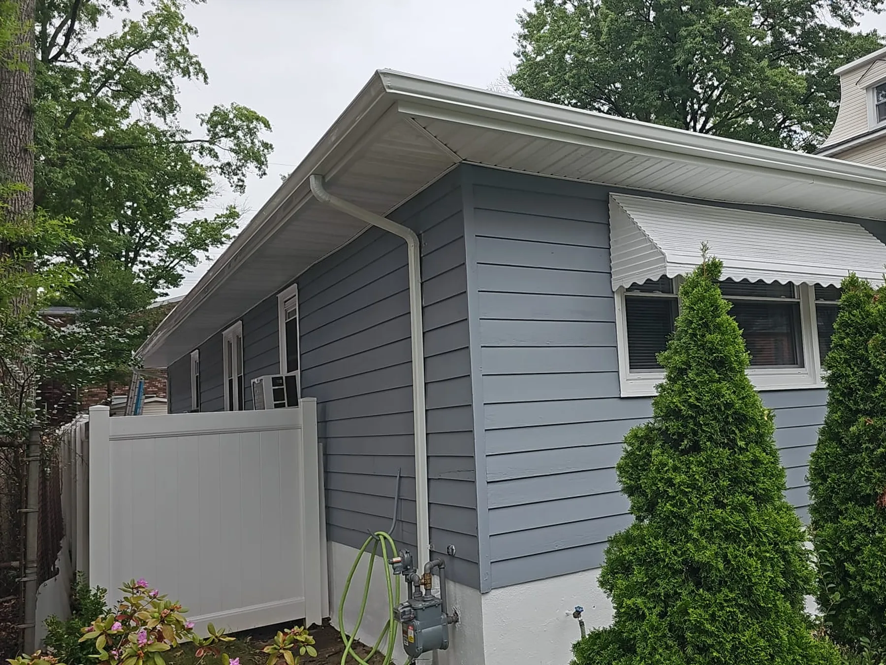 Newly installed gutters on a blue-gray home exterior