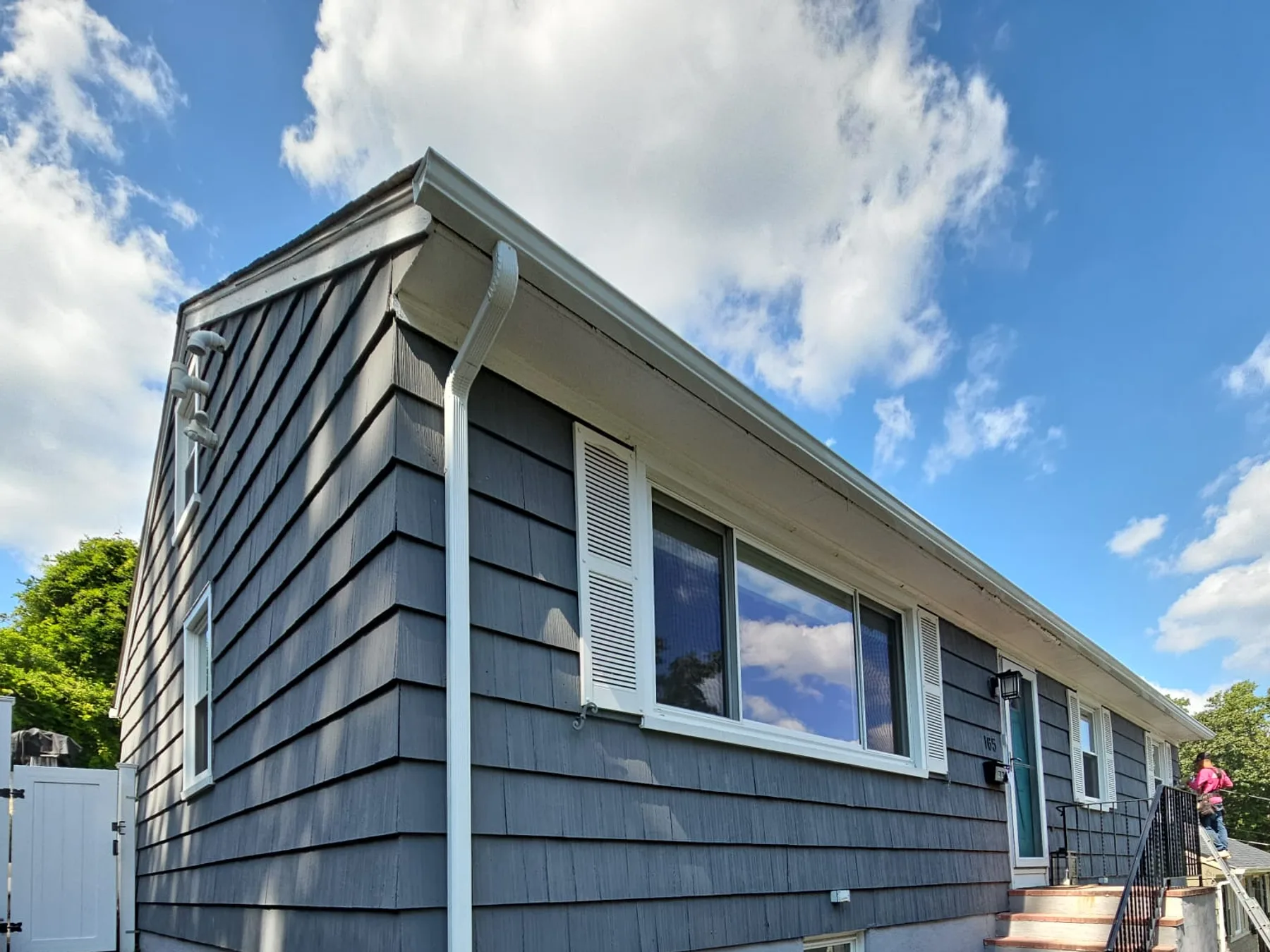 Finished gutters on a gray shake home with a patio