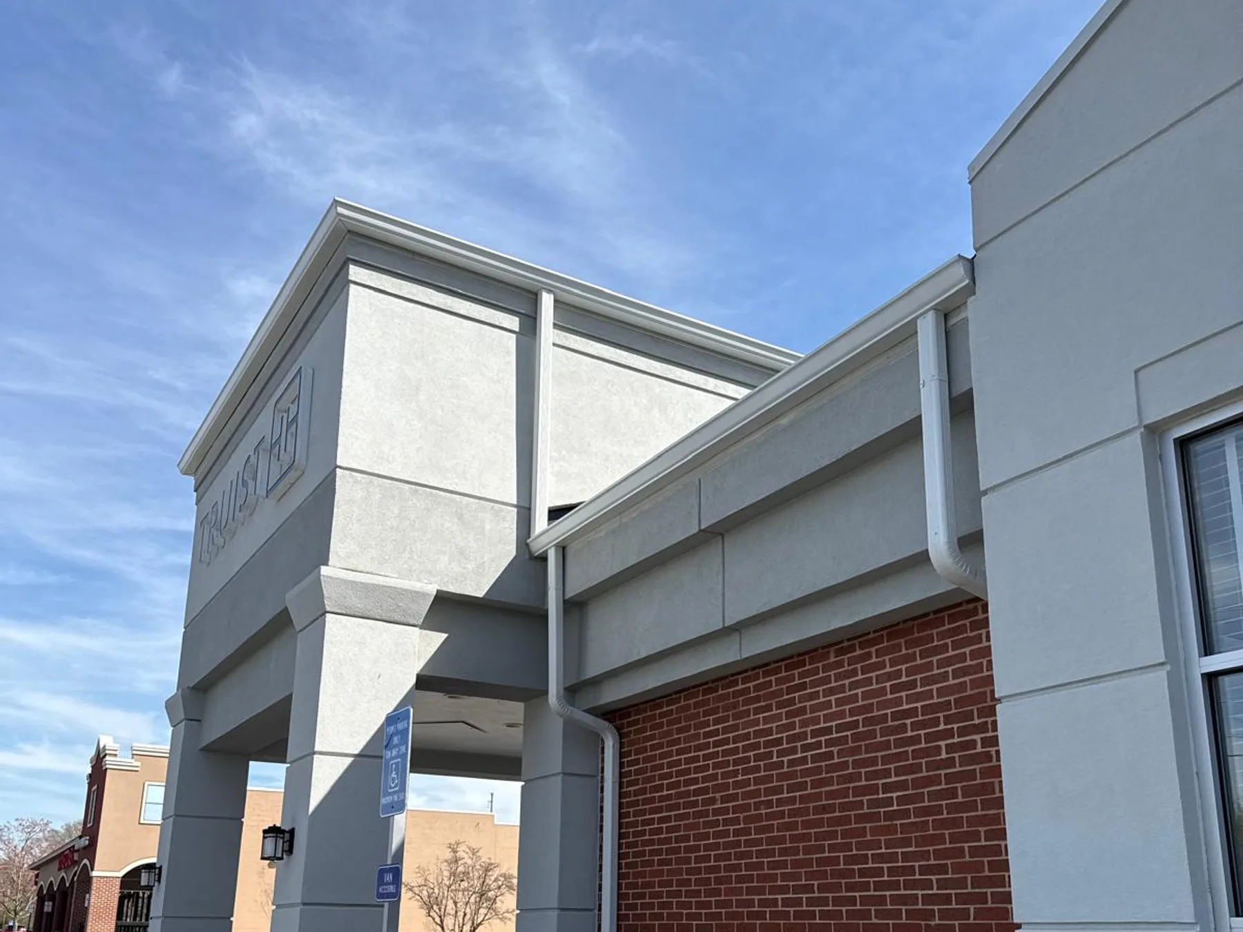Commercial gutter installation on a retail building storefront